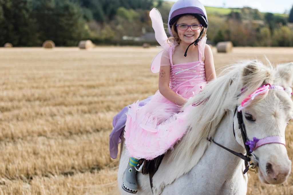 Girl dressed as fairy on horse
