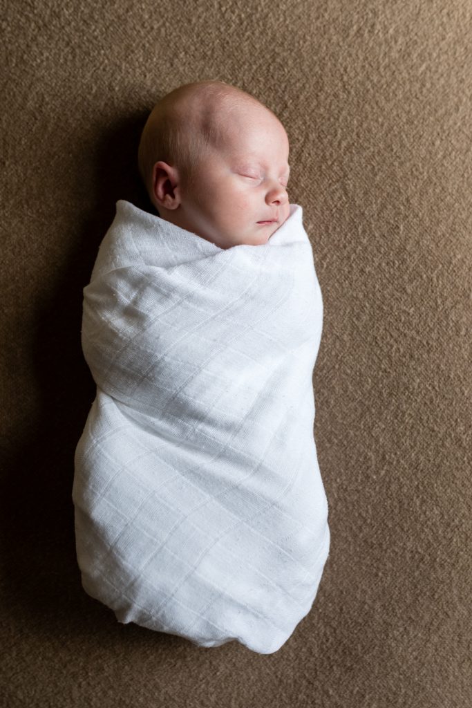 Newborn baby in white swaddle on brown blanket - baby photographer aberdeen - Debbie Dee Photography